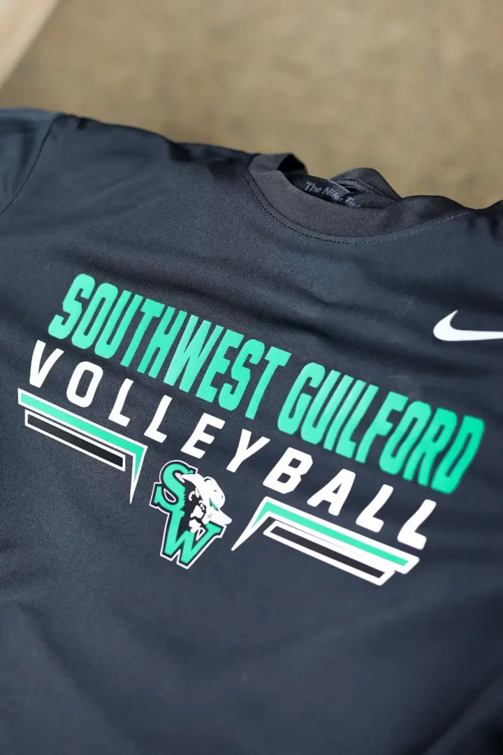 Close-up of a folded black Southwest Guilford Volleyball shirt with custom screen print design