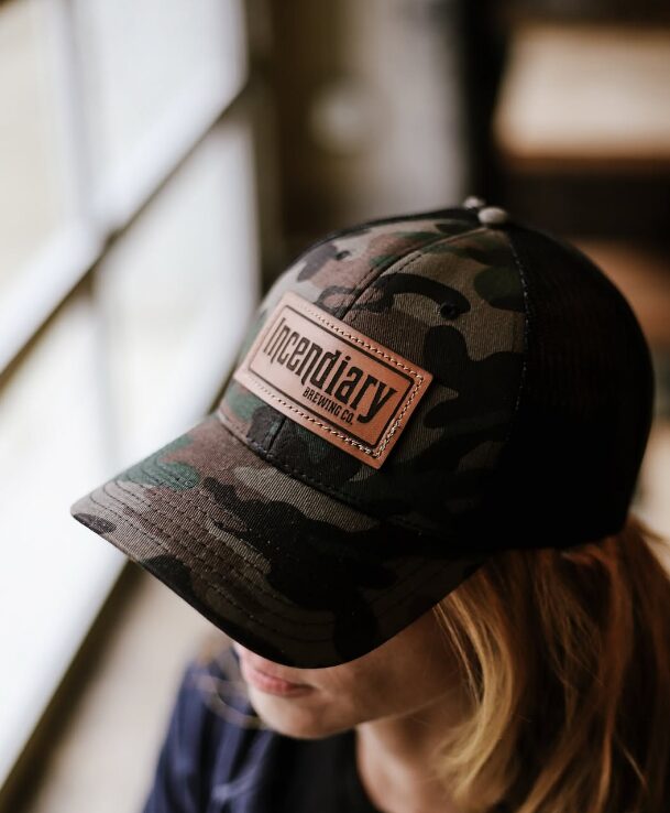 Custom camo trucker hat with a rectangular leather patch logo for local brewery merchandise